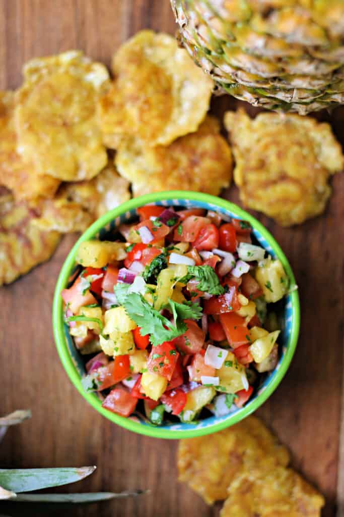 Pineapple Pico de Gallo salsa in a small bowl with plantain chips in the background.