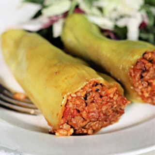 Two stuffed Cubanelle peppers on a plate.