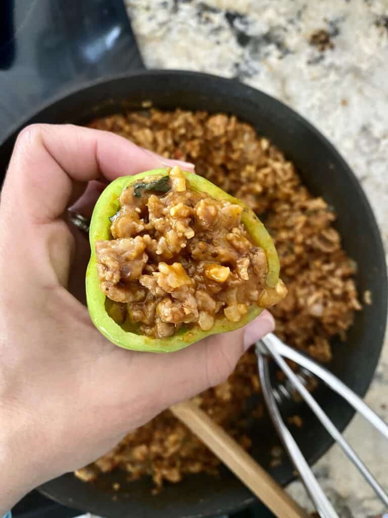 Close up of stuffed Cubanelle pepper with filling and scoop in background.