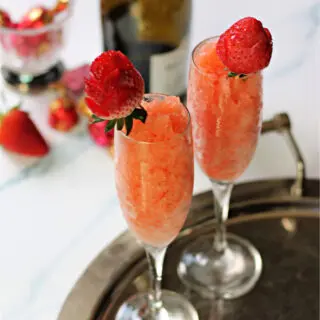 Two Strawberry & Champagne Granitas in champagne flutes on a silver serving tray.