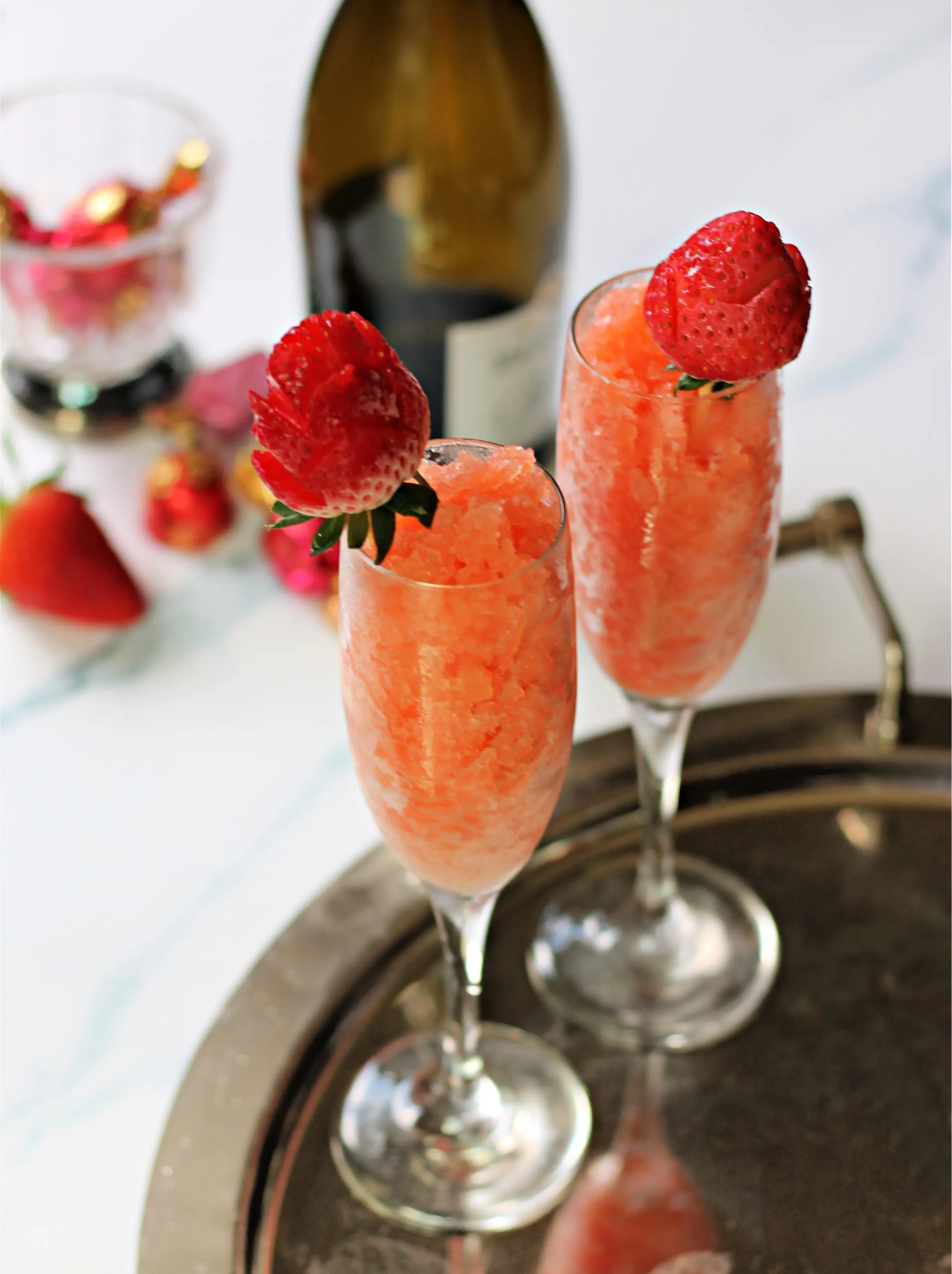 Two Strawberry & Champagne Granitas in champagne flutes on a silver serving tray.