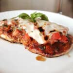 A piece of Baked Brushetta Chicken on a white plate.