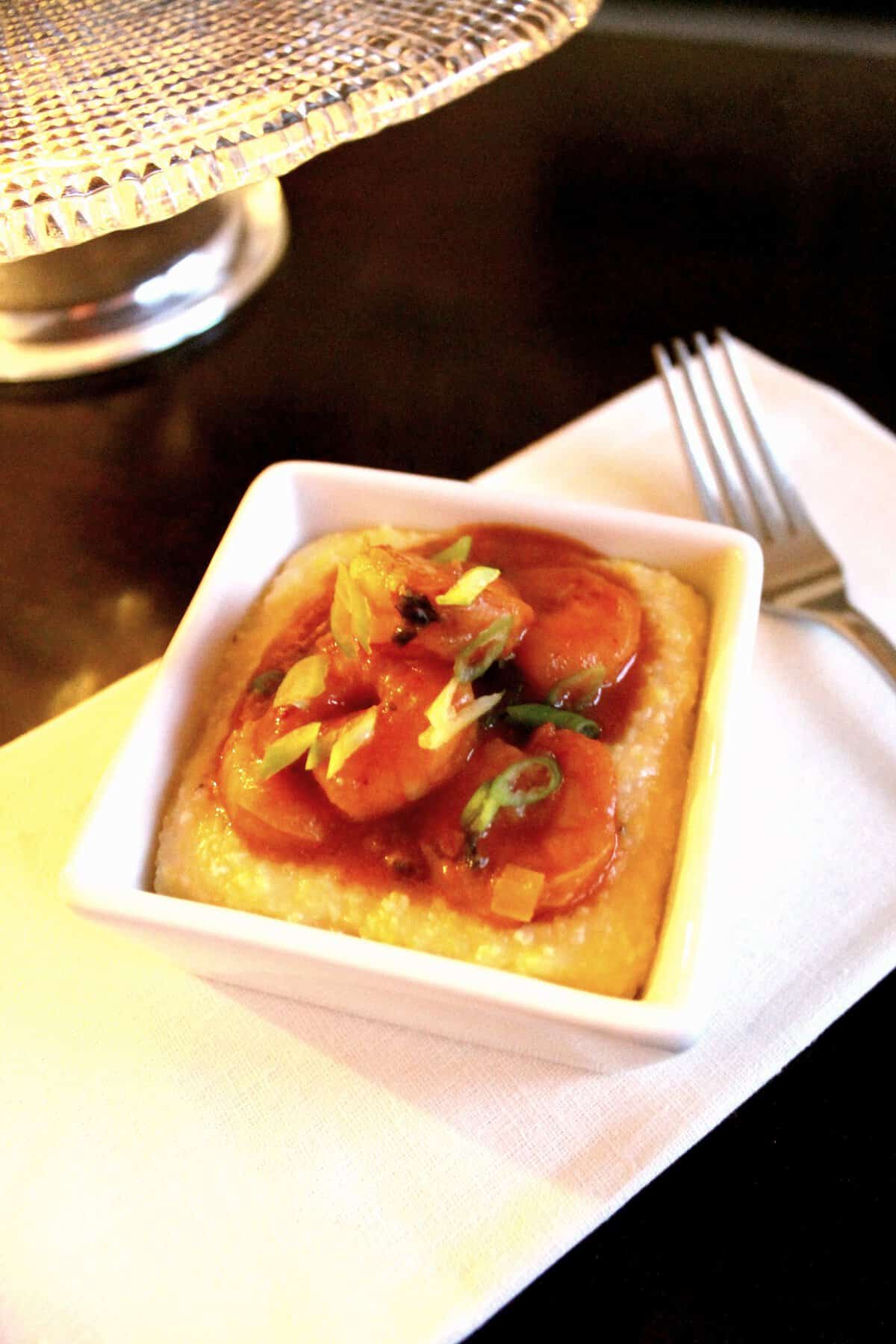 Saucy Shrimp with Polenta in a white dish.