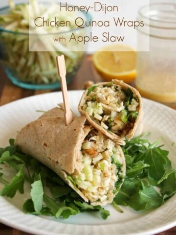 Healthy Chicken Wraps cut in half and placed on a bed of arugula on a white plate.