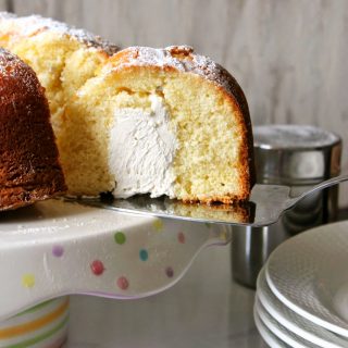 A slice of Twinkie Bundt cake being removed from a cake plate.