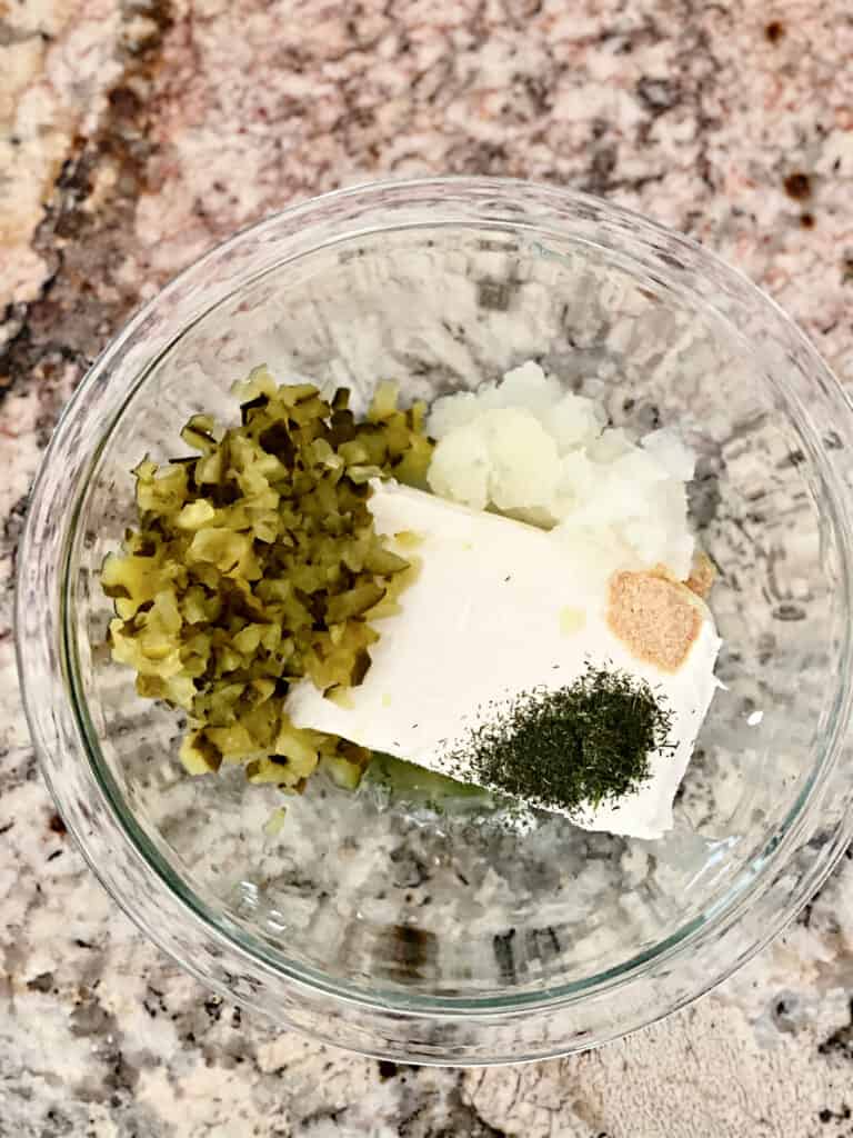 Ingredients for Dill Pickle Dip in a clear glass bowl.