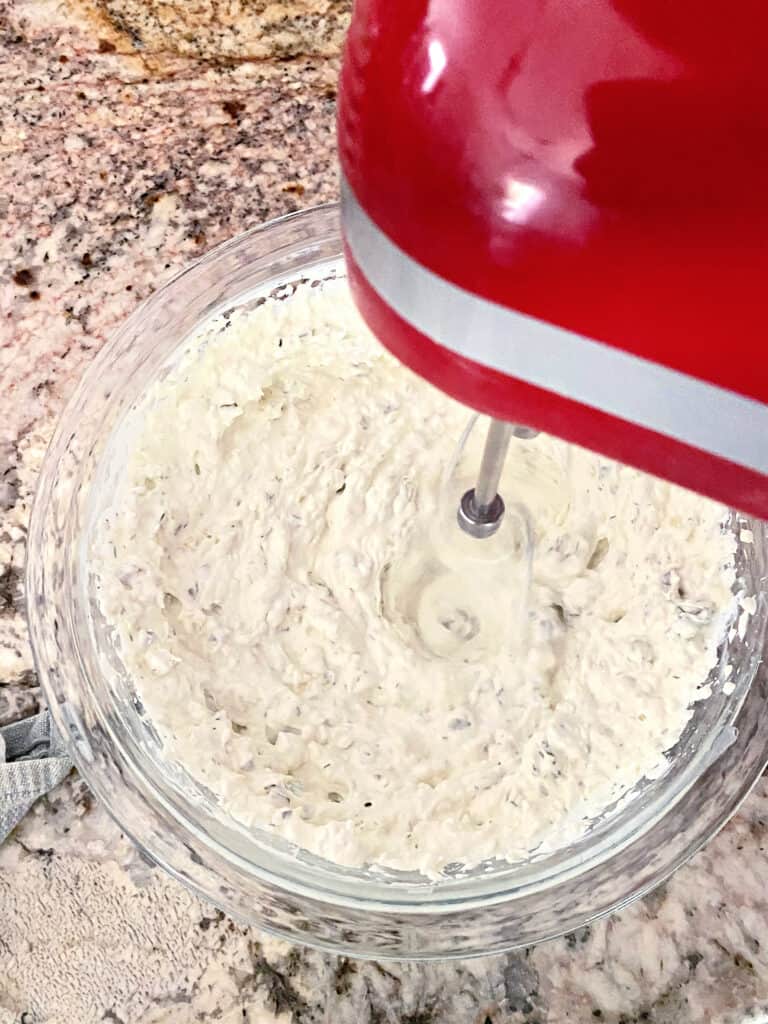 Dill Pickle Dip being blended with a hand mixer.