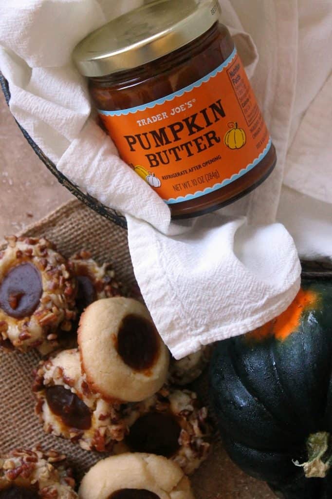 Pumpkin Butter Thumbprint Cookies! The ultimate fall cookies, these sweet treats are rolled in crunchy toasted pecans and filled with a delicious spiced store-bought pumpkin butter. A great cookie to make for fall holidays! 