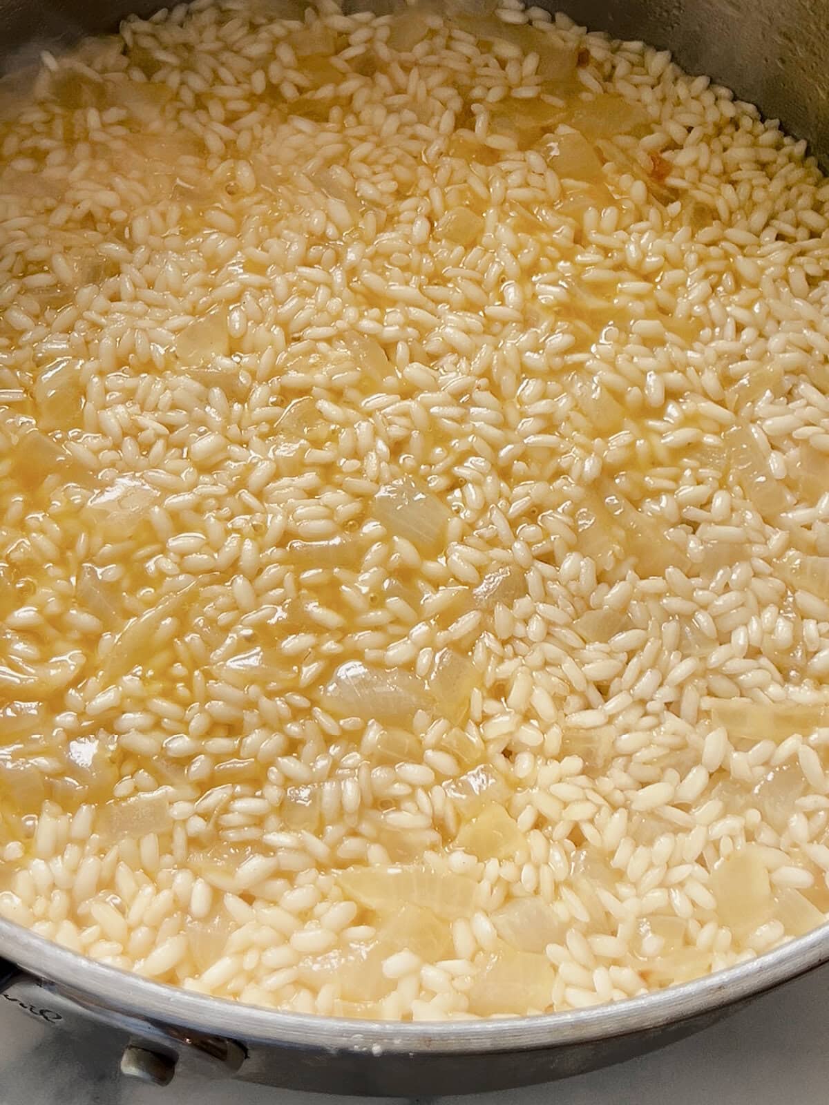 Arborio rice in a pan to show the liquid has been absorbed before the next step.
