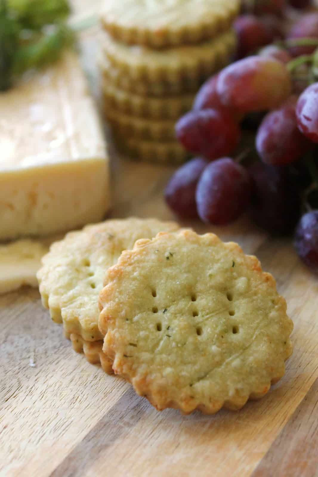 Close up of cheese wafers to show texture with cheese board items in background.
