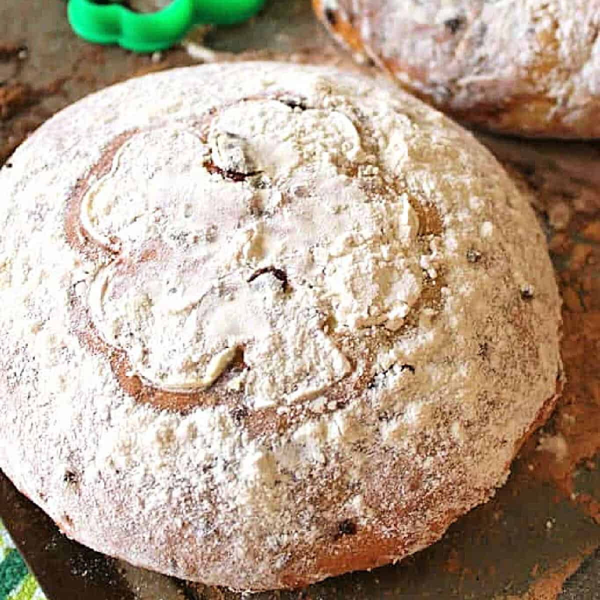 A loaf of Irish Cheddar Bread with a shamrock shape drawn in to the flour on top.