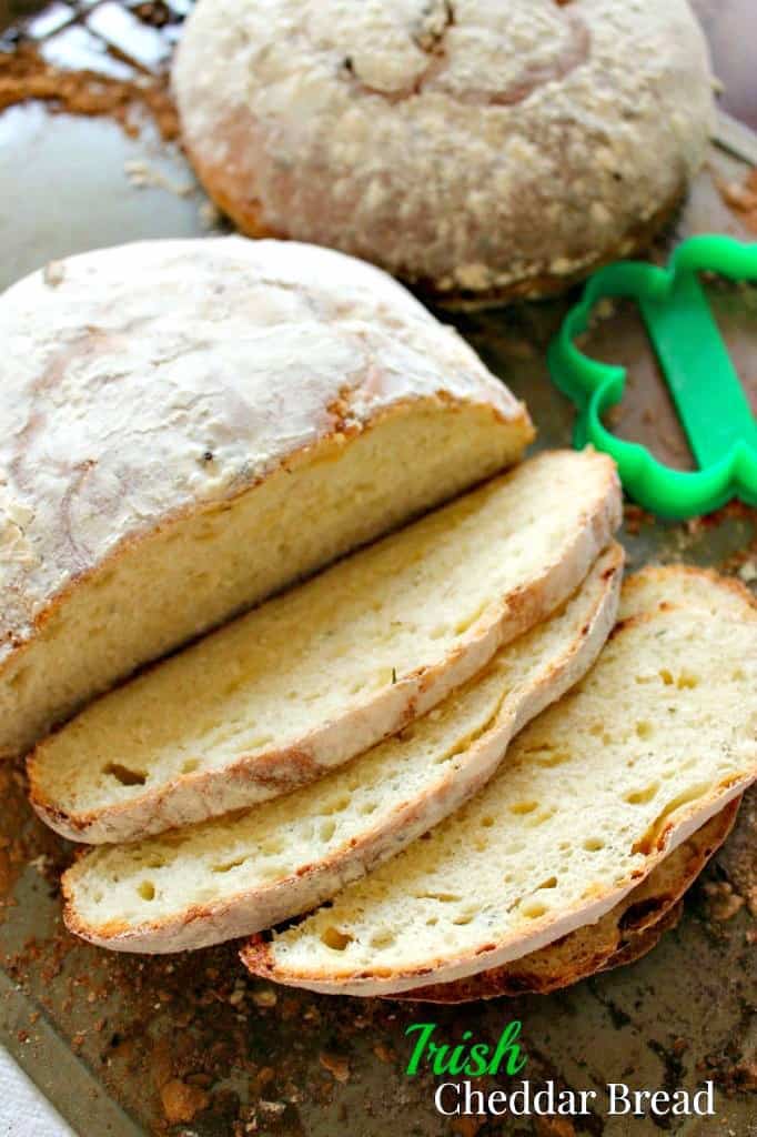 A sliced loaf of Irish Cheddar bread on a dark surface.