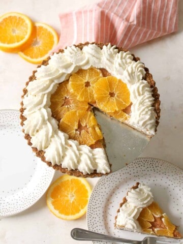Orange Dreamsicle Tart! A simple crust of pulverized graham cracker and sweetened coconut flakes makes the ideal, tropical vessel for a condensed-milk sweetened citrus custard, lightened with airy, beaten egg whites. Decorated with a halo of fluffy, vanilla-scented whipped cream, this dessert is definitely one heavenly dream!