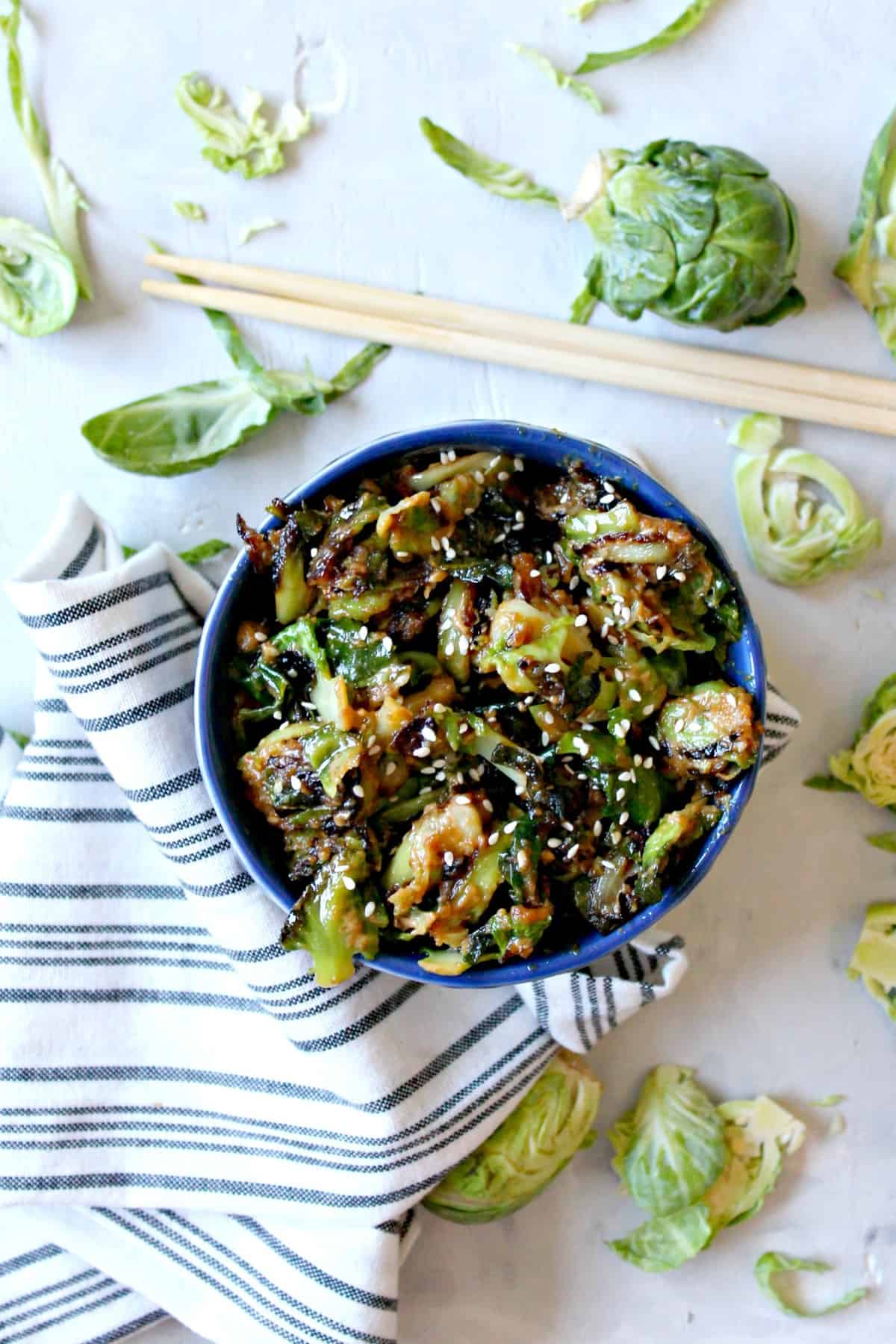 Sesame Peanut Brussels Sprouts! If you or your family need convincing that Brussels sprouts can be delicious, this recipe is the ticket to a clean plate! Savory peanut butter sauce with a dash of sweetness and a hint of spice glaze these sprouts for a side dish that will grace your table again and again. 