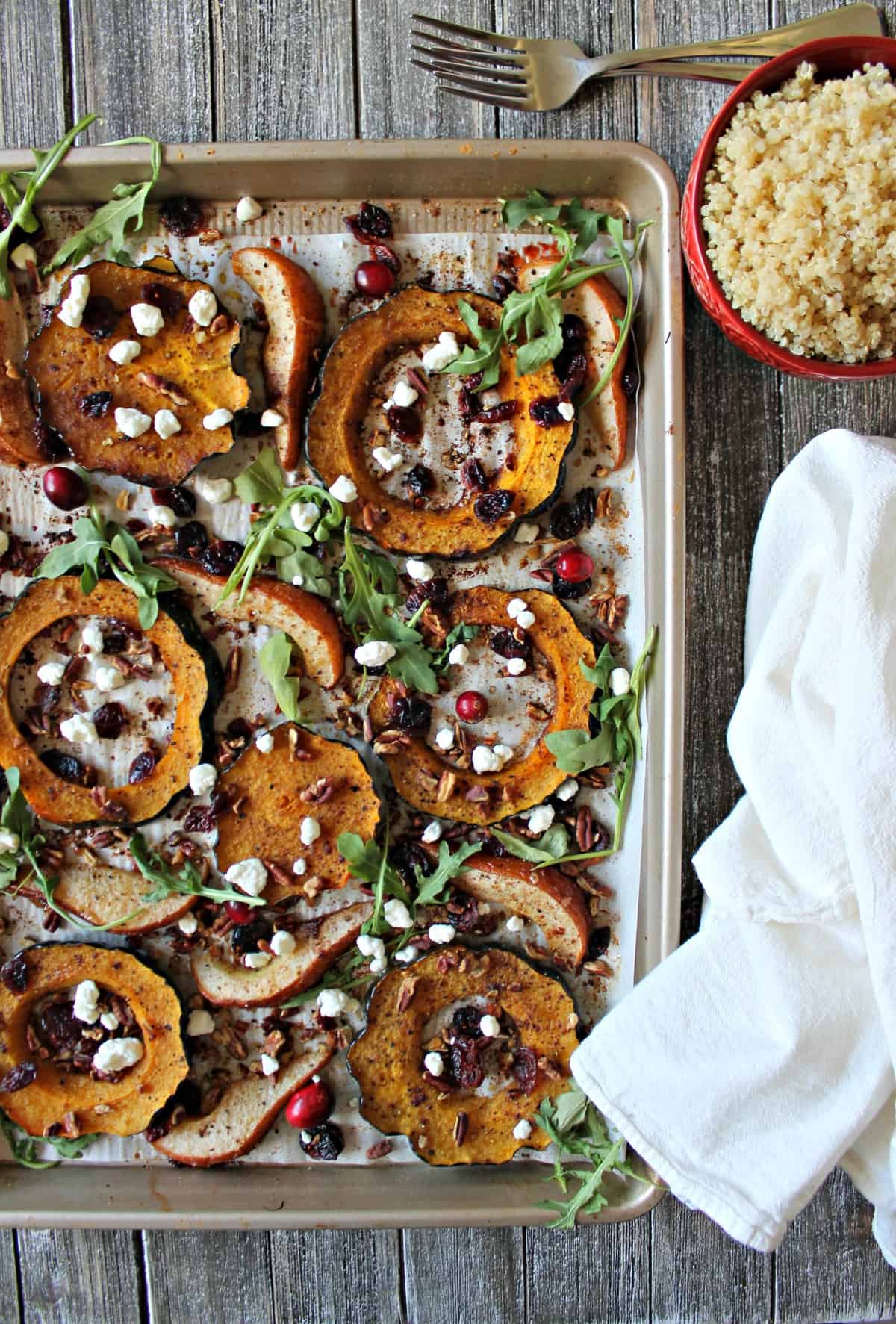 Spiced acorn squash, pears and quinoa cook simultaneously in the oven before being tossed with dried cranberries, pecans, goat cheese, and fresh arugula.