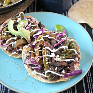 Charred Shishito Pepper & Refried Bean Tostadas! Just because these crunchy tostadas come together quickly doesn't mean they lack any flavor! Charred Shishito peppers, onions and refried beans drizzled with a Cumin & Lime Yogurt Sauce make a quick but delicious meal.