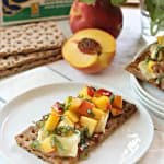Hot Honey Peach & Brie Bruschetta! Ripe, diced peaches tossed with fresh basil, placed atop warm brie & drizzled with spicy honey on a hearty crispbread.  The flavor of summer!