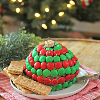 Mint Cookies & Cream Dessert Cheese Ball! Crushed creme-filled chocolate cookies stud a sweet and creamy cheesecake "ornament". A hint of mint gives it a holiday twist! This last minute holiday dessert couldn't get any easier or cuter! Serve with fruit or cookies for a festive treat.