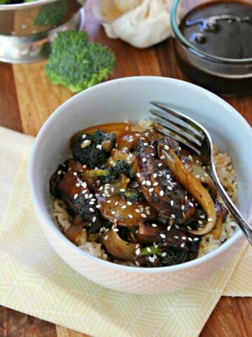 Teriyaki Mushroom Bowls! Sweet and salty homemade teriyaki glaze coats hearty portobellos, caramelized onions and broccoli, served over rice or noodles. Faster than takeout, these mushroom bowls take no time at all to prepare, making it a perfect dinner for meatless Mondays.