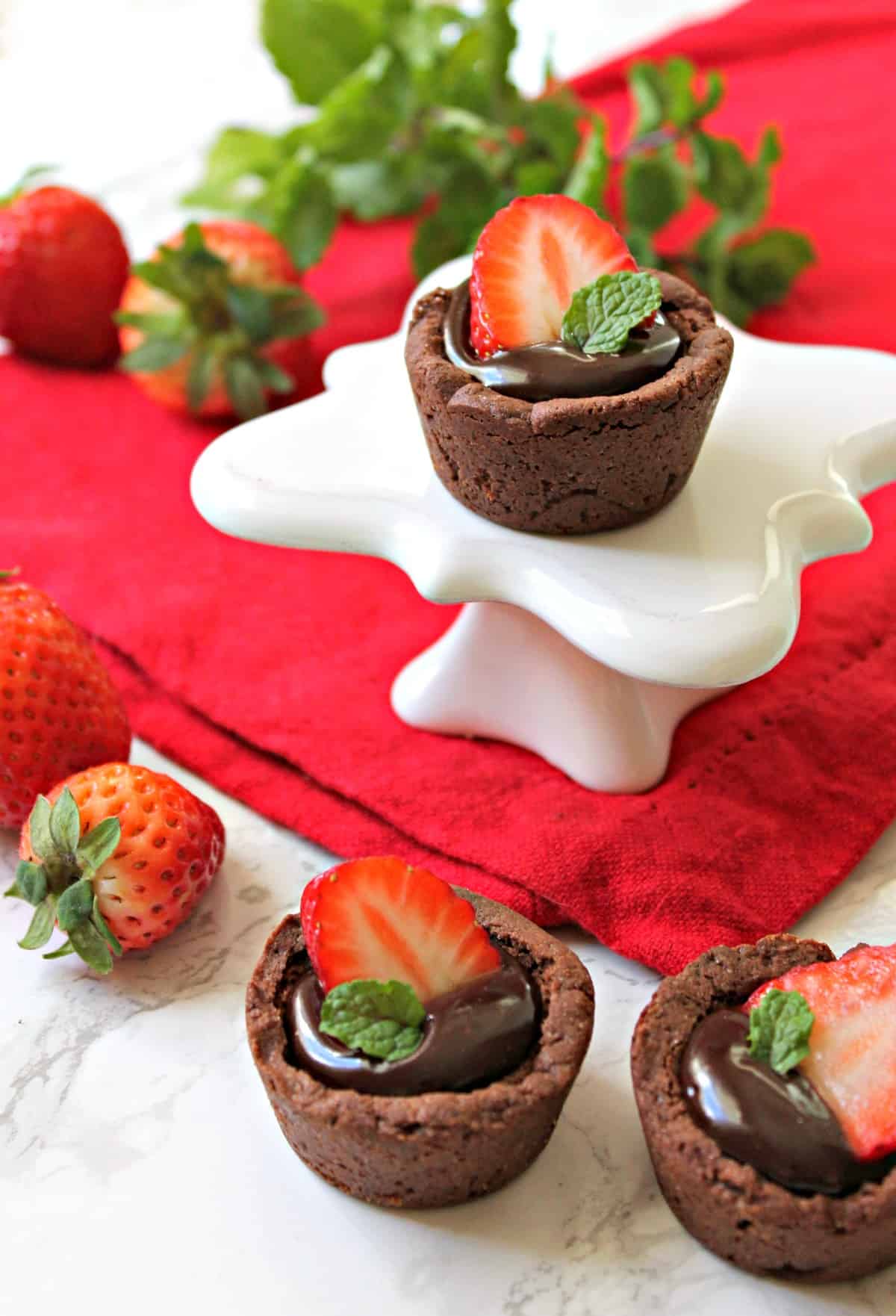 Strawberry & Chocolate Ganache Cookie Cups! Need any easy Valentine's Day treat?  These chocolate cookie "cups" are filled with smooth, creamy chocolate ganache and topped with fresh strawberries for a crowd-pleasing dessert that comes together in no time. 