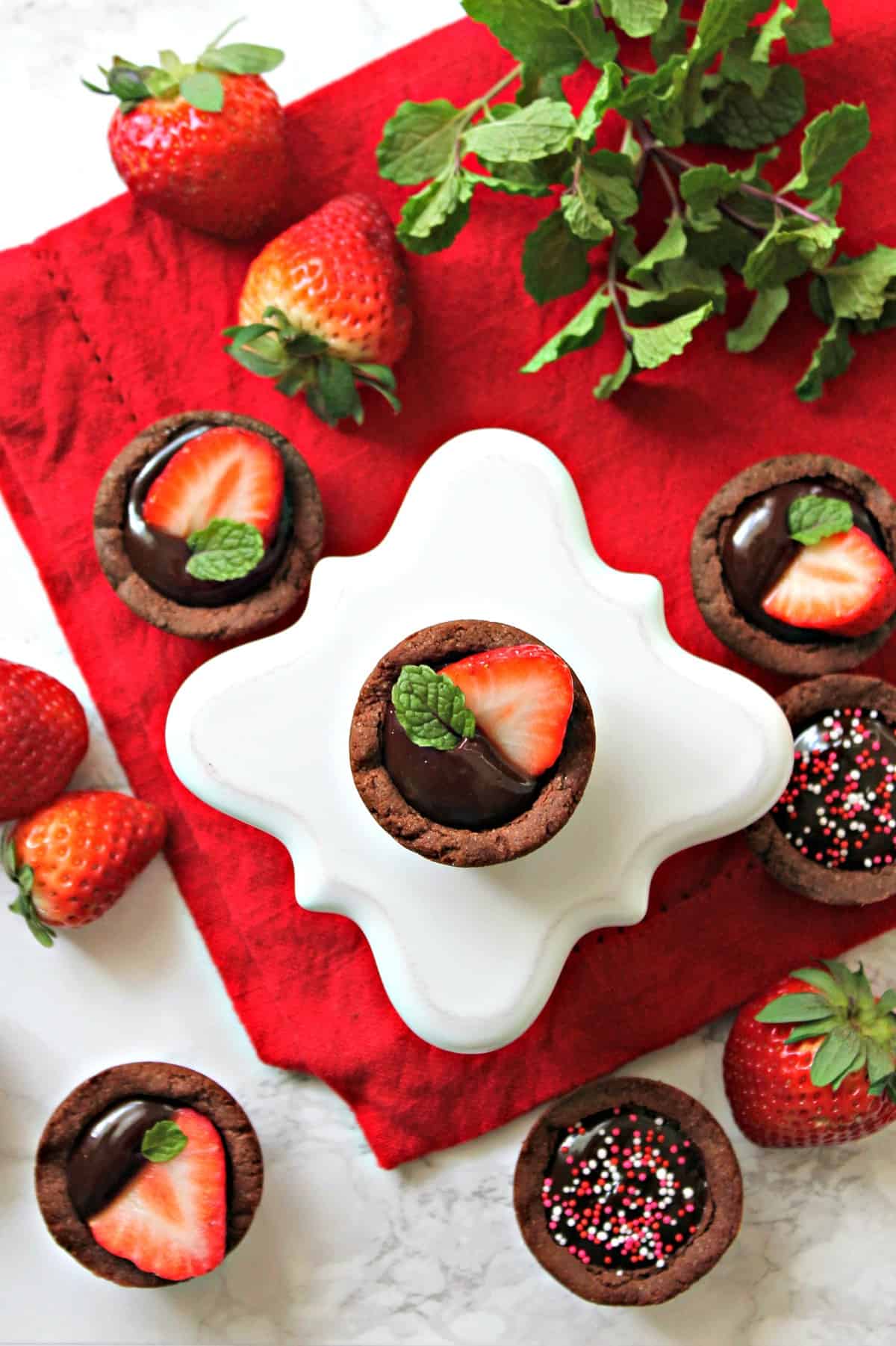 Strawberry & Chocolate Ganache Cookie Cups! Need any easy Valentine's Day treat?  These chocolate cookie "cups" are filled with smooth, creamy chocolate ganache and topped with fresh strawberries for a crowd-pleasing dessert that comes together in no time. 