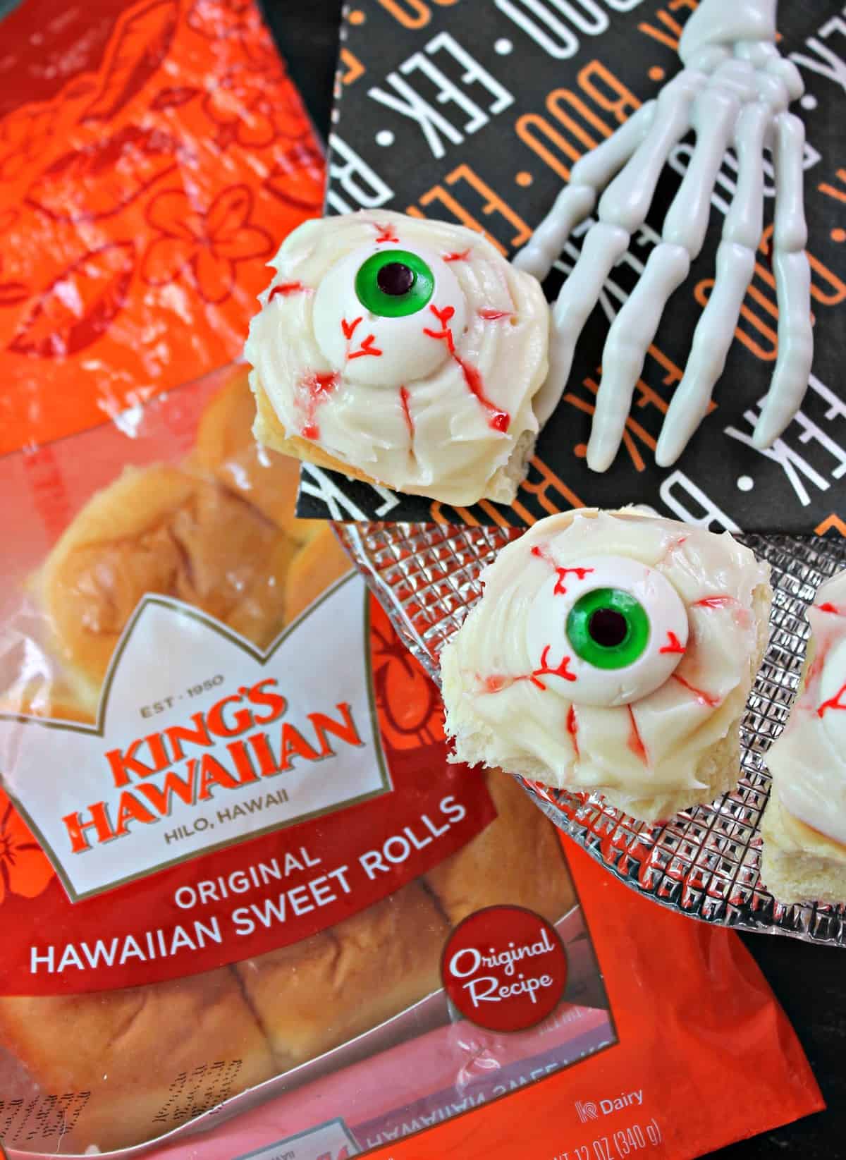 Spooky Eyeball Sweet Rolls! Need something quick and easy to make for Halloween festivities? These ooey, gooey, no-bake sweet rolls come together quickly with the help of King's Hawaiian Dinner Rolls! Filled with raspberry jam and topped with a creamy glaze and gummy eyeballs, they'll become your family's favorite creepy treat! 