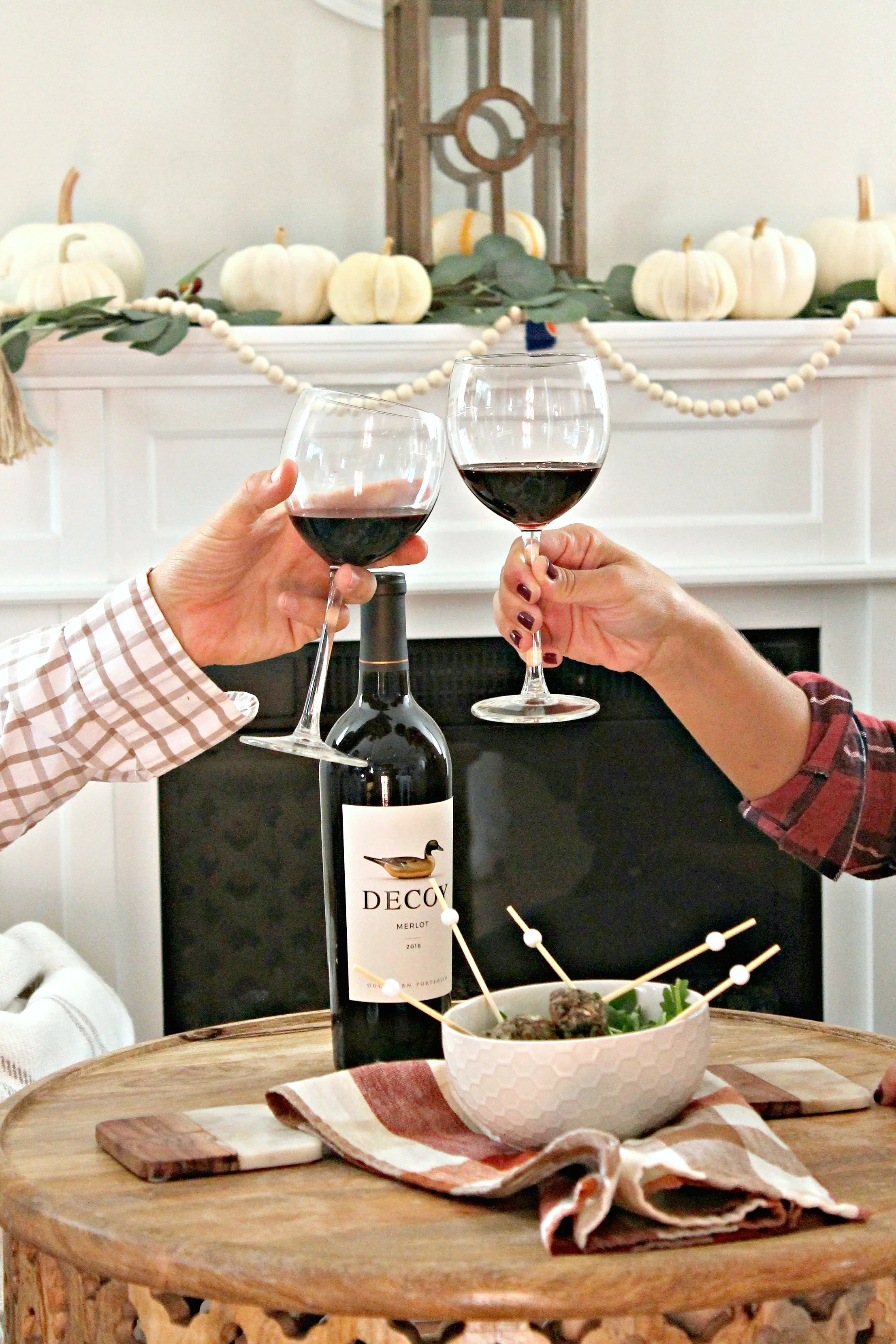 Close up of two people toasting with merlot wine in glasses.