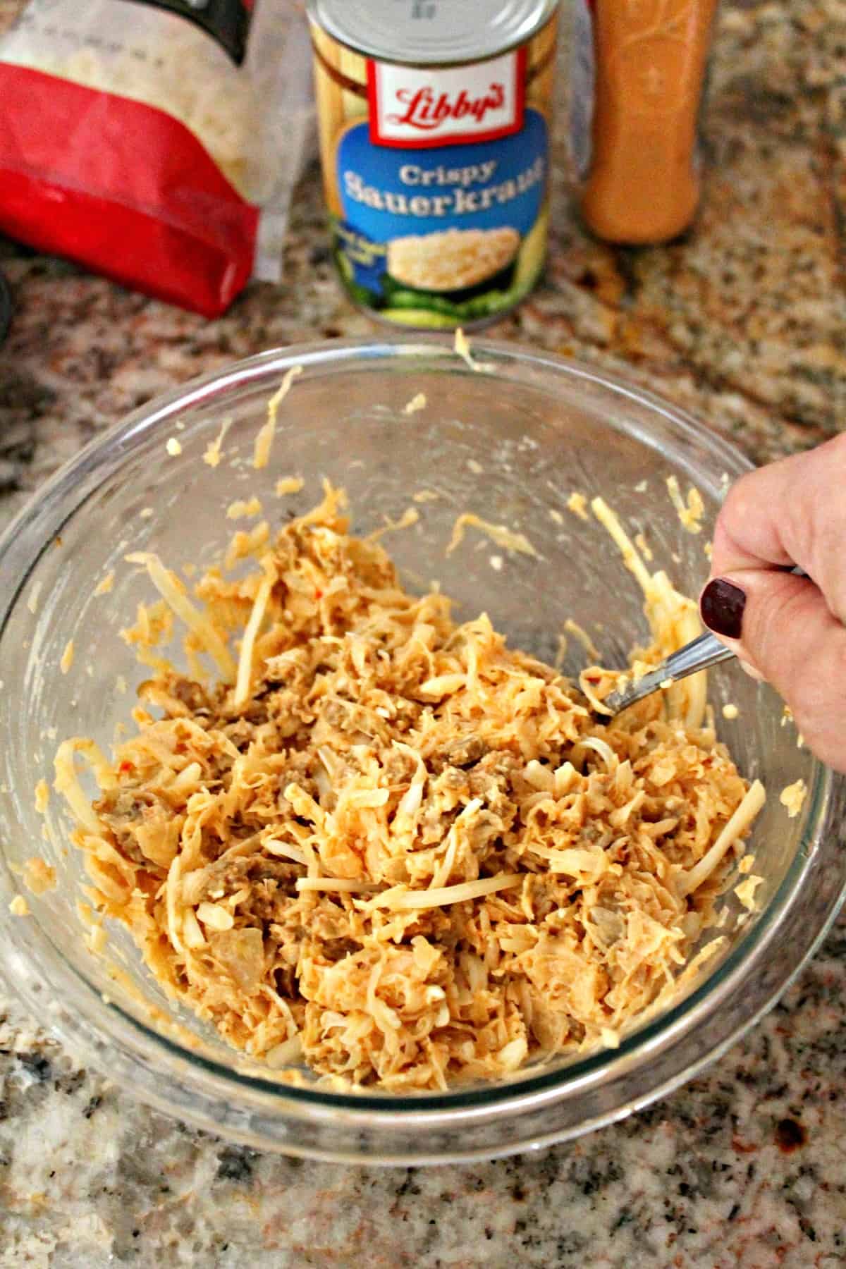 Process shot: Combining sauerkraut and Russian dressing in a bowl.