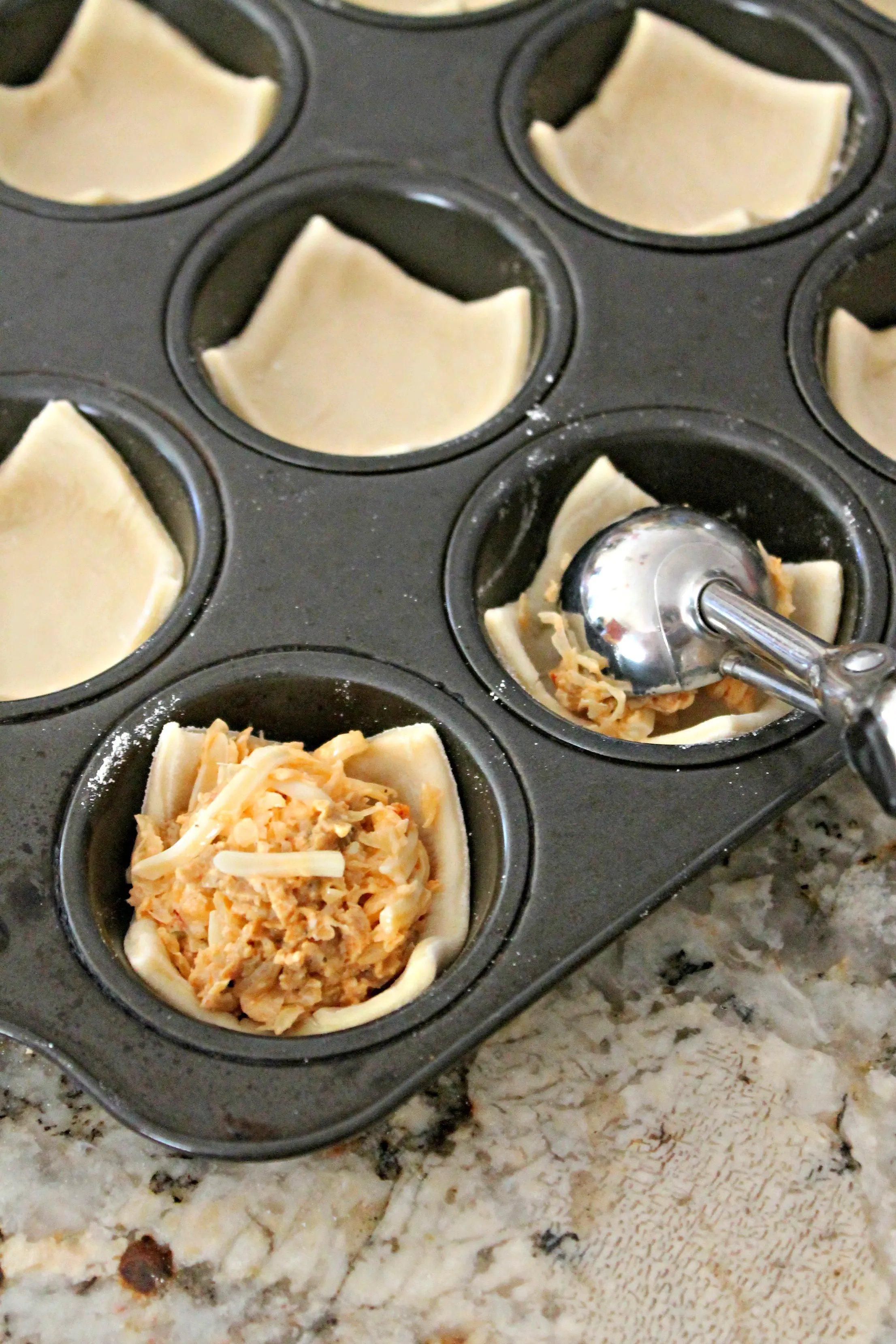 Process shot: Scooping filling into puff pastry cups.