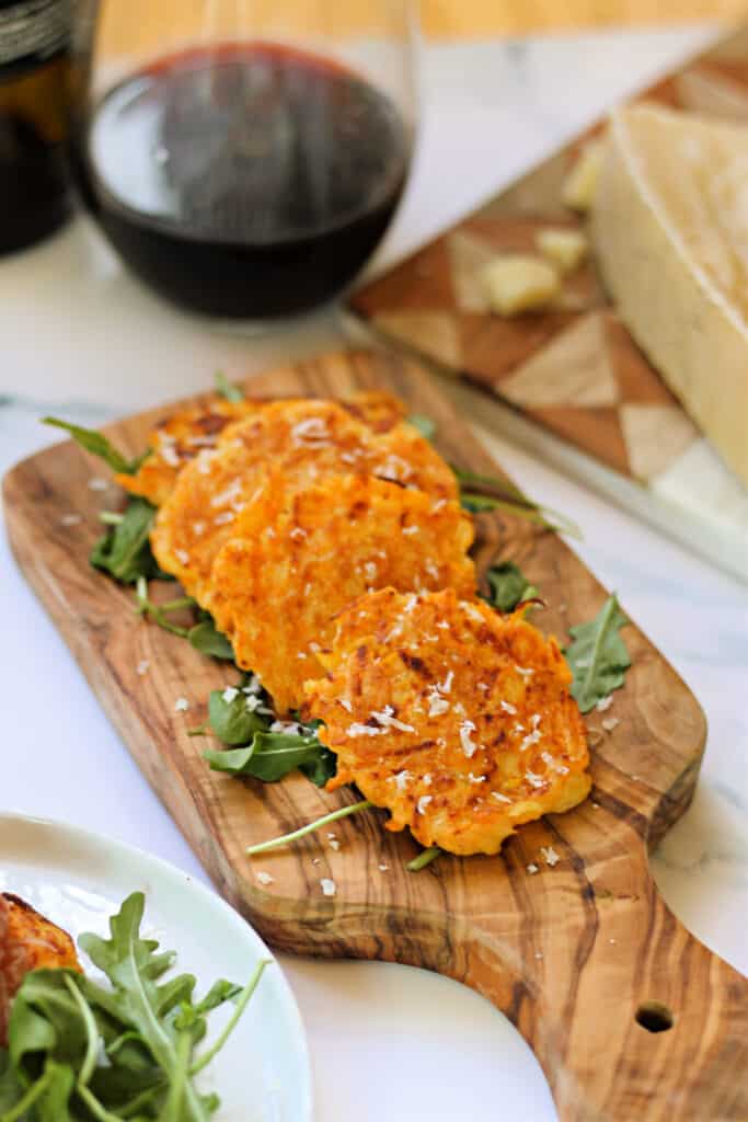 Butternut squash fritter appetizers on a small wood board.
