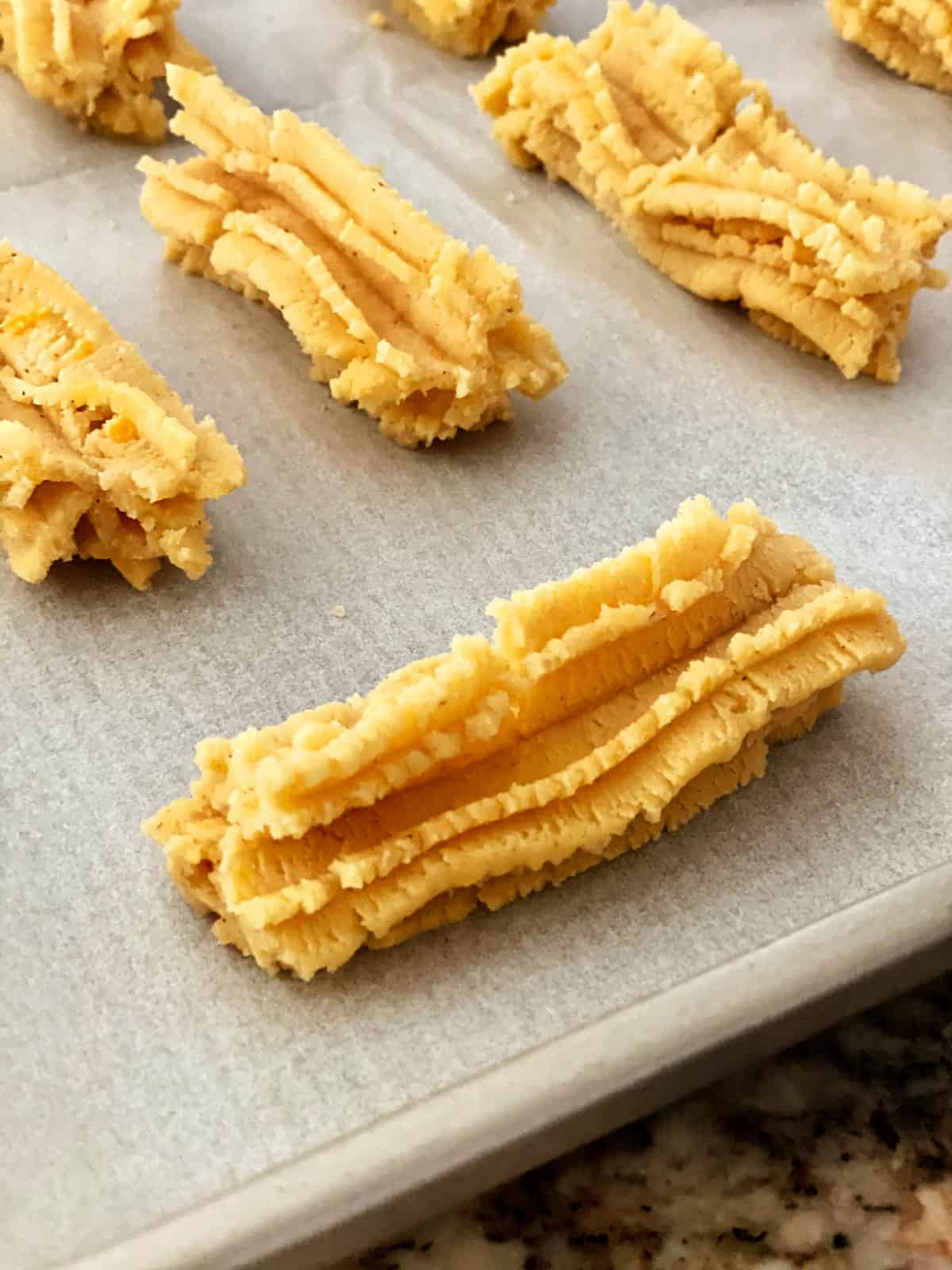 Southern Cheese Straw dough on a parchment-lined sheet pan.