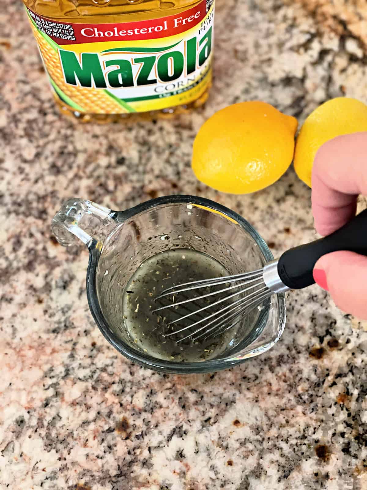 Whisking marinade in a glass measuring cup.