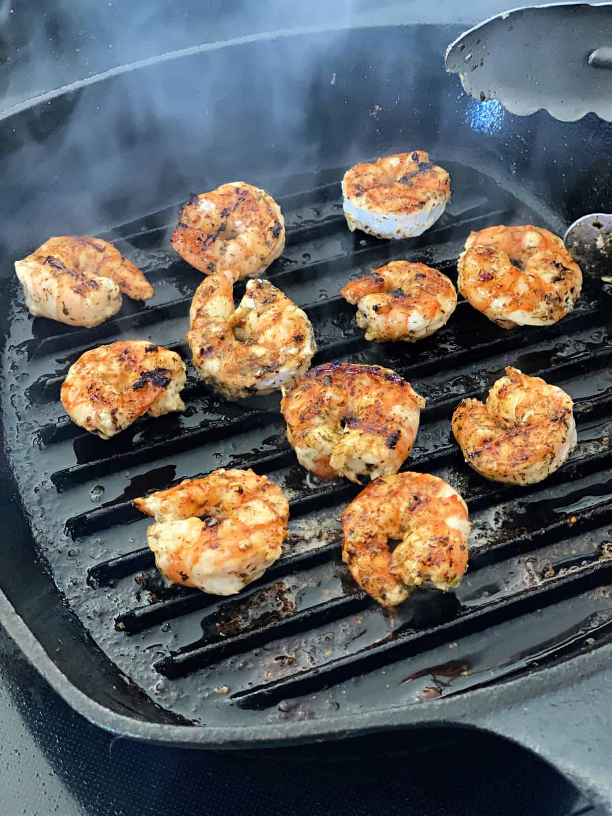 Marinated Shrimp cooking on a grill pan.