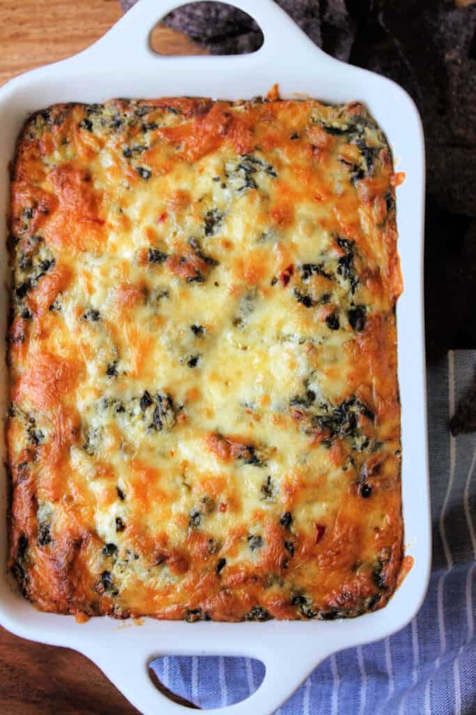 Hot Spinach & Artichoke Dip in a white baking dish.