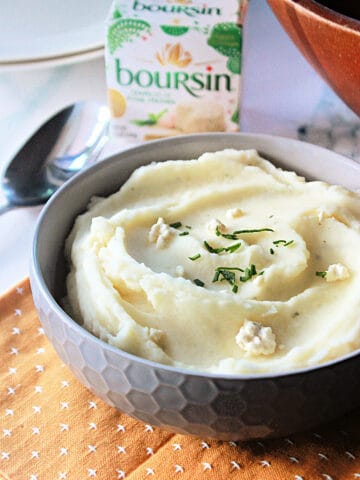 A close up of Boursin Mashed Potatoes in a gray serving bowl.