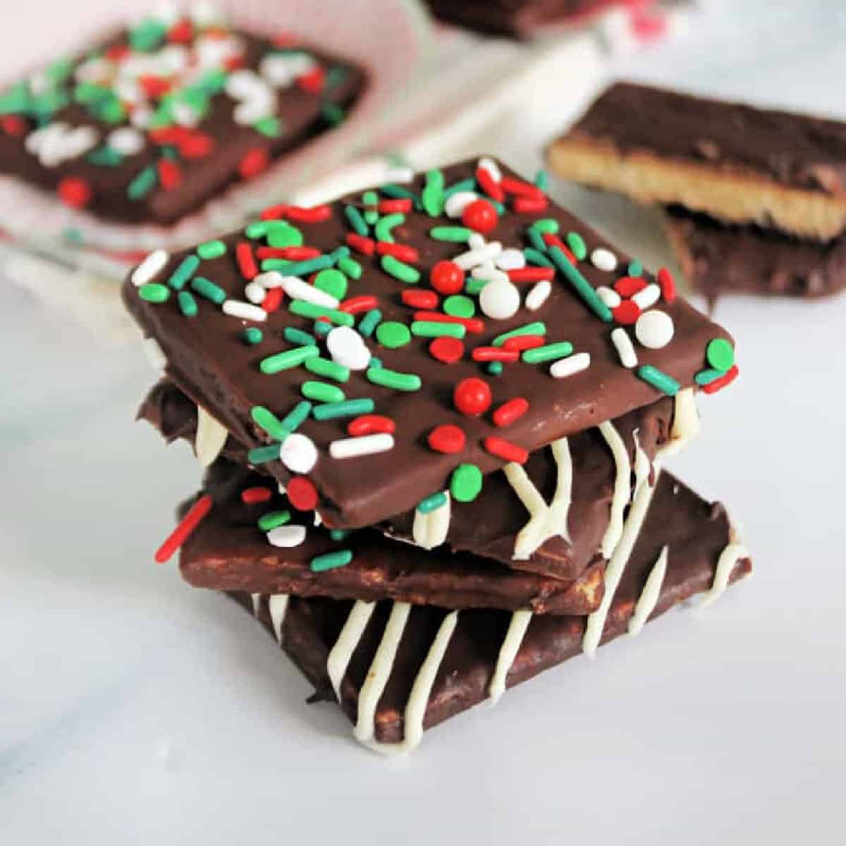 Chocolate Covered Graham Crackers piled on top of each other on a marble background.