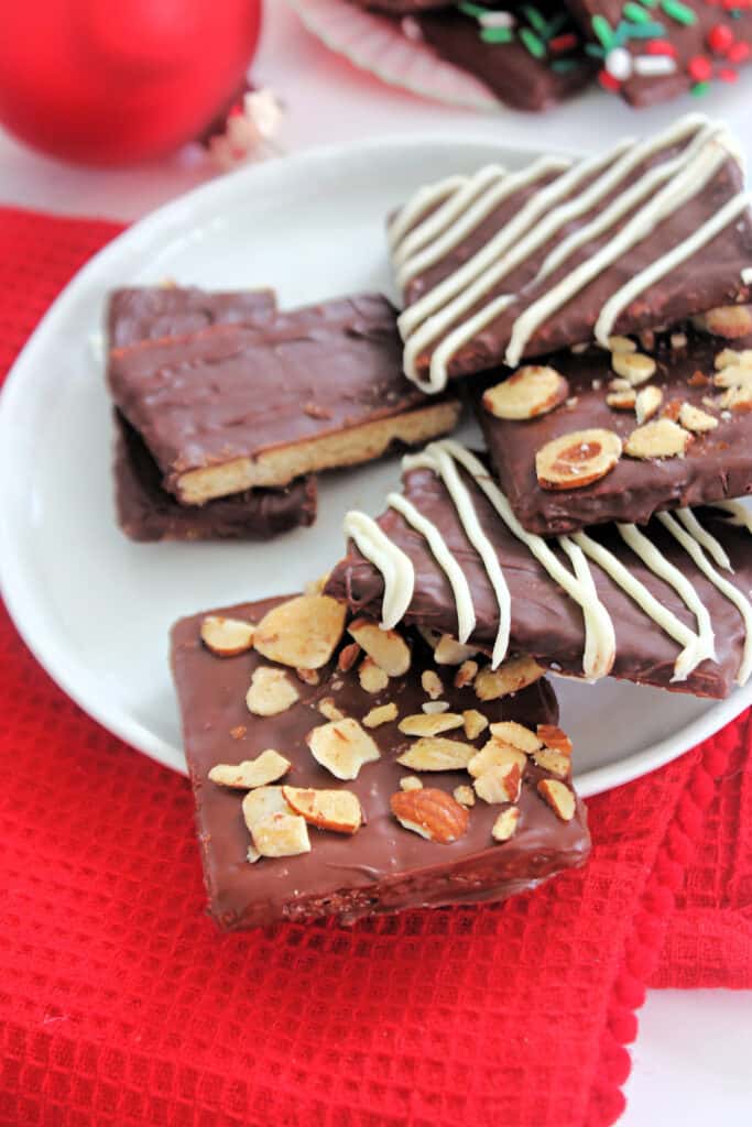 A white plate with Chocolate Covered Graham Crackers with all different toppings.