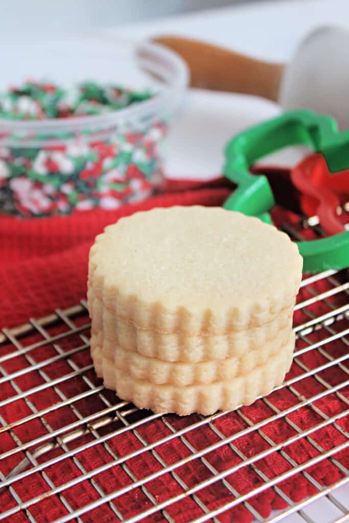 A stack of scalloped No Spread Sugar Cookies on a baking rack.