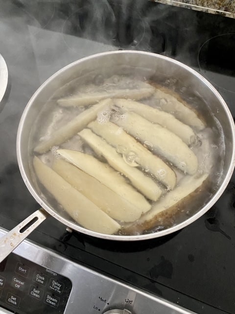 Boiling potato wedges.