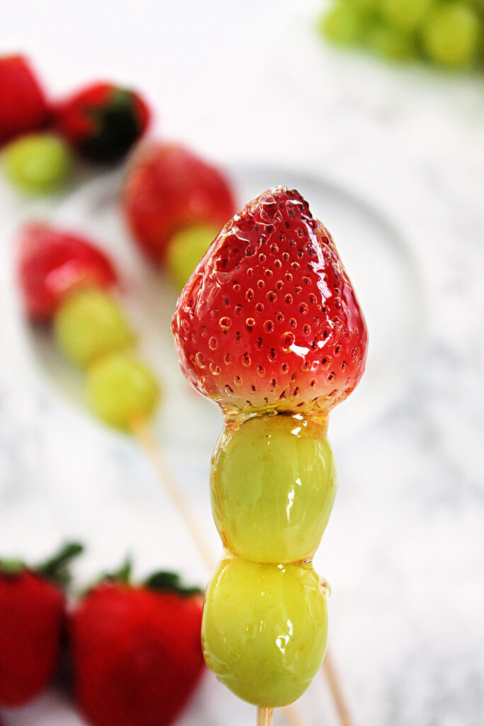 Strawberry tangulu with grapes on a skewer.