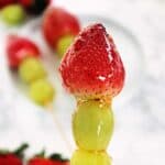 Strawberry tangulu with grapes on a skewer.