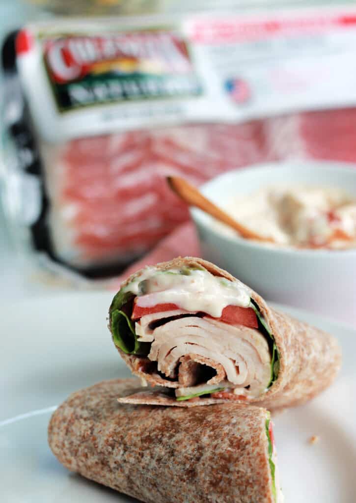 A finished turkey wrap on a white plate to show the use of bacon aioli. 