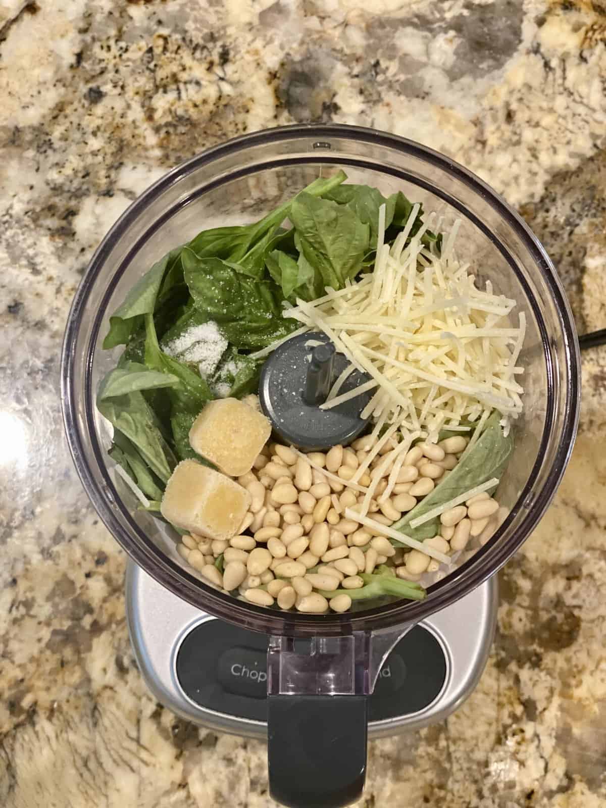 Ingredients for pesto in a food processor.