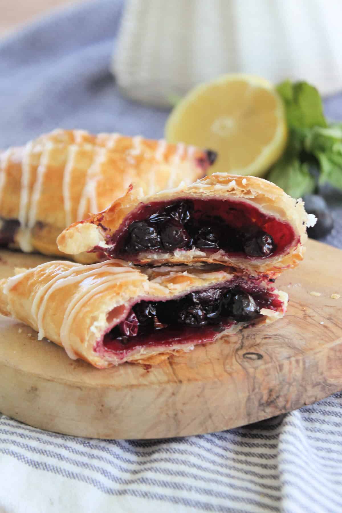 A blueberry turnover cut in half to show the texture of the blueberry filling on the inside.