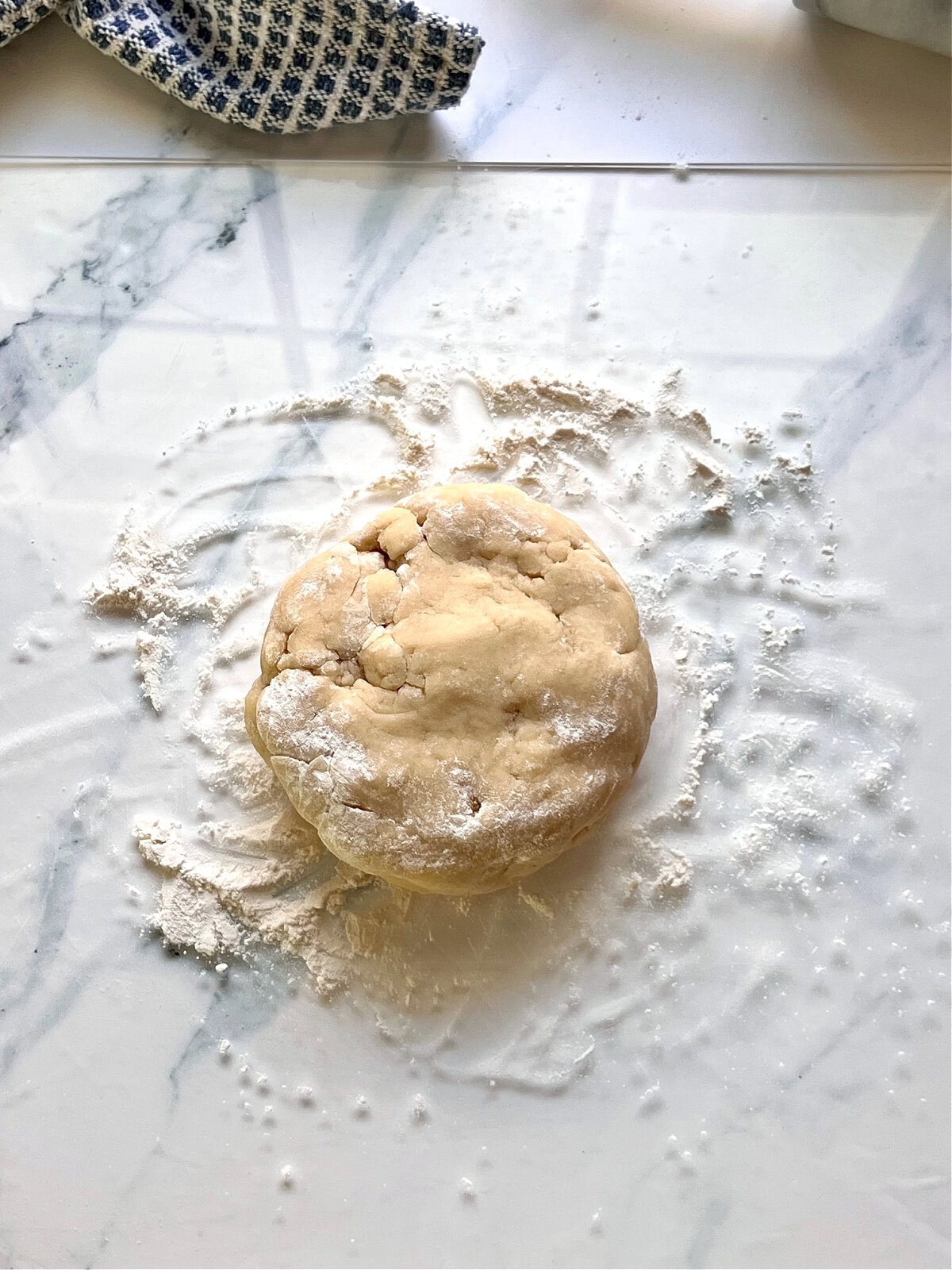 A ball of pie dough on a floured surface.