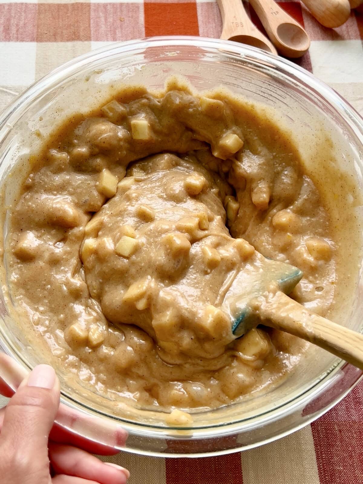 Mixing diced apples into the batter for apple spice cake.