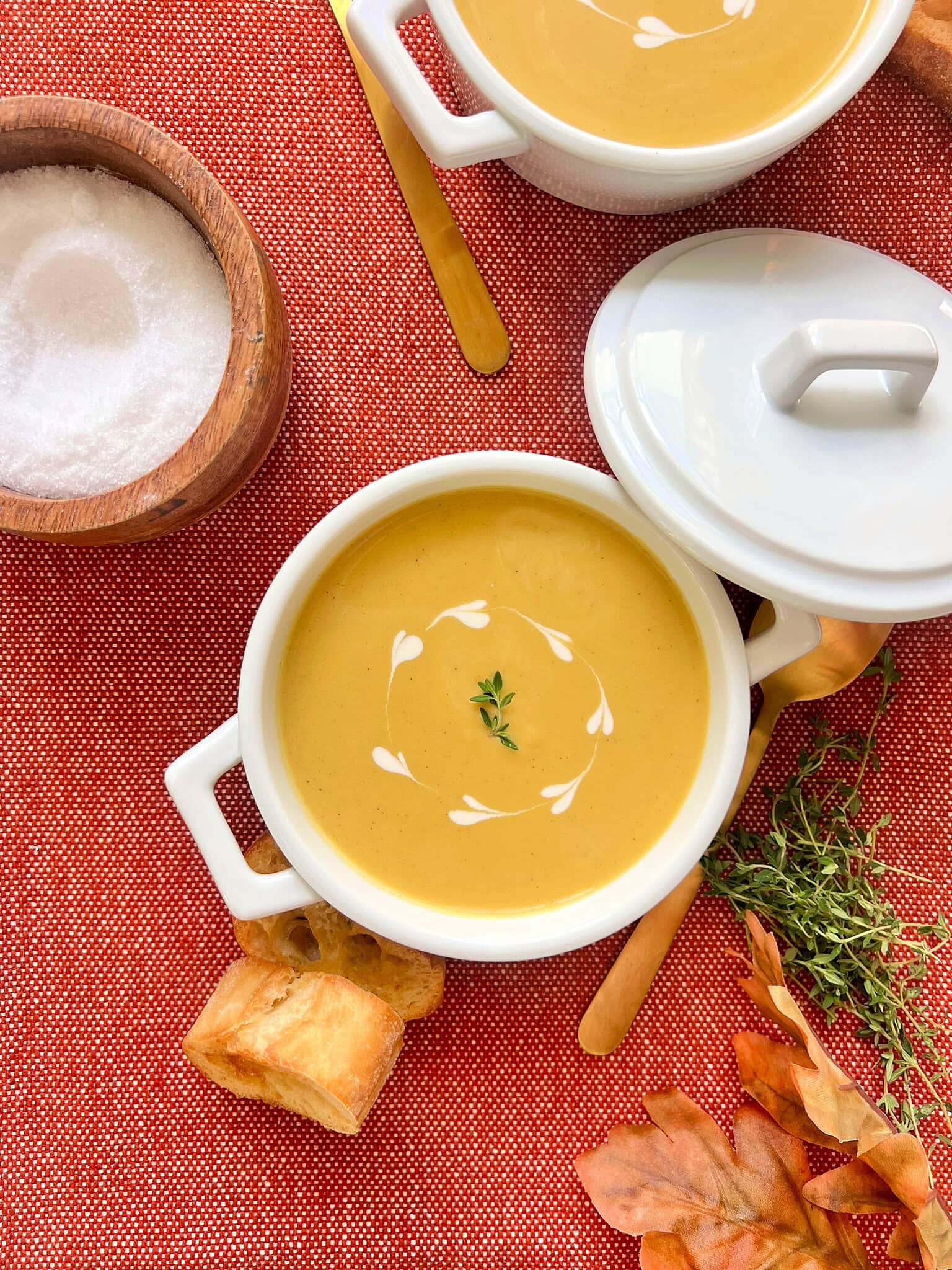 Overhead shot of butternut squash soup in a small white pot.