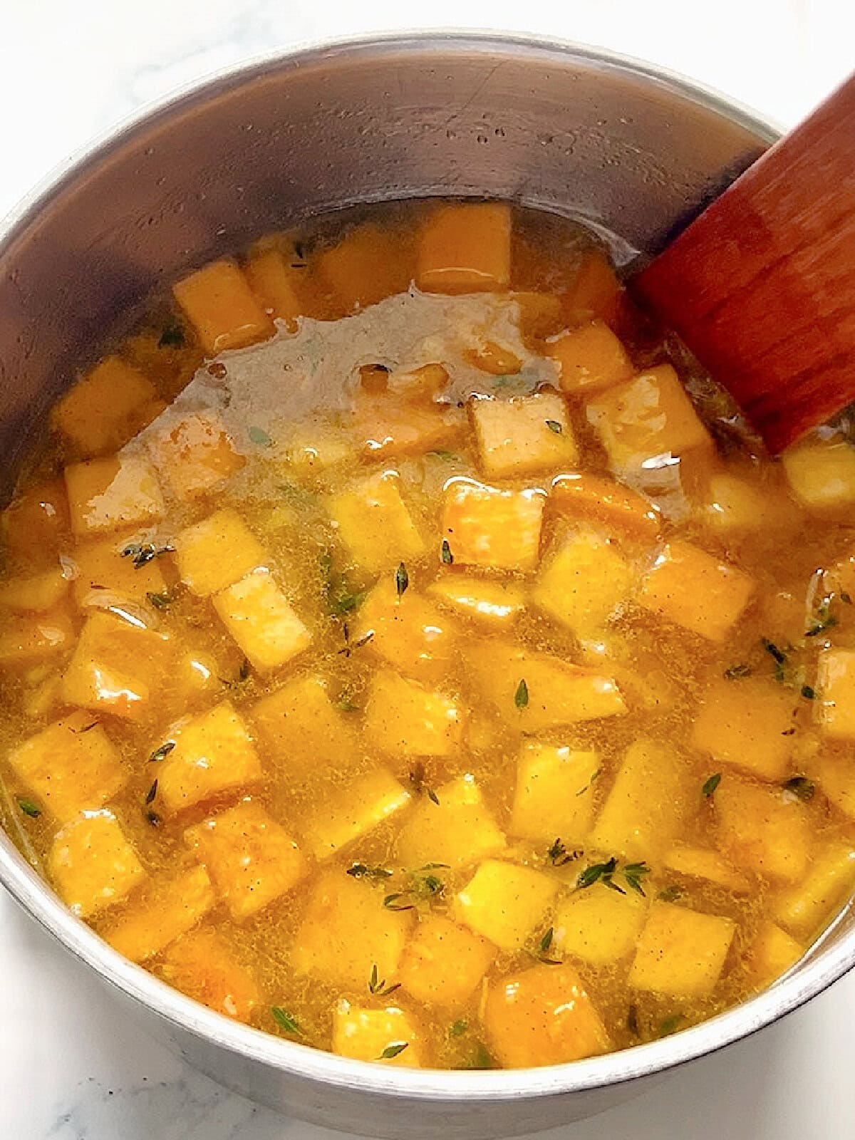 Broth and cubed butternut squash added to the pot.