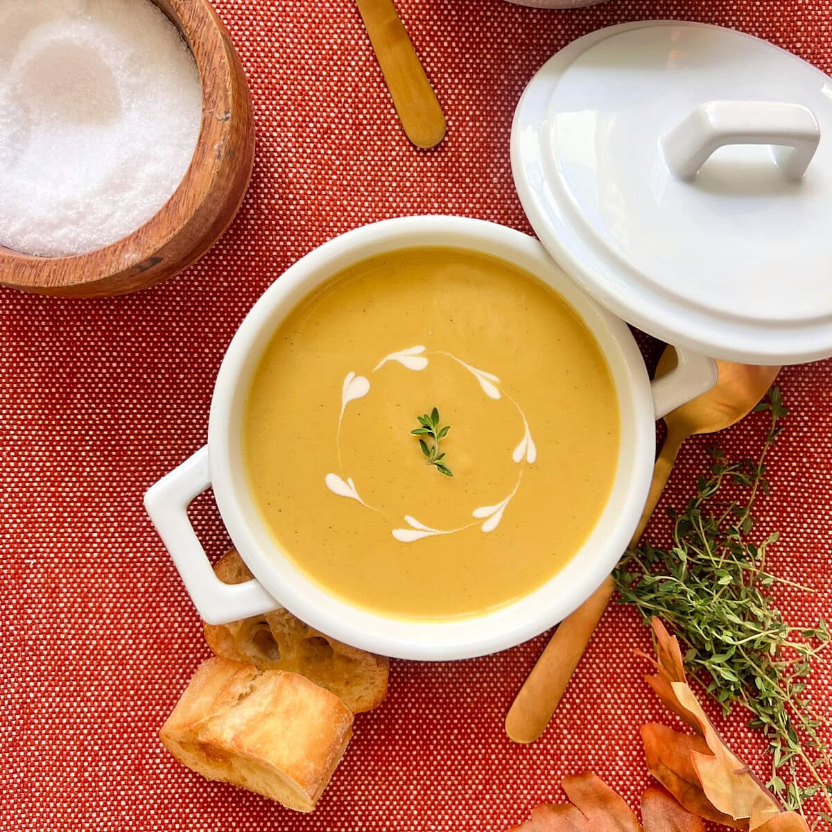 Overhead shot of butternut squash soup in a small white pot.