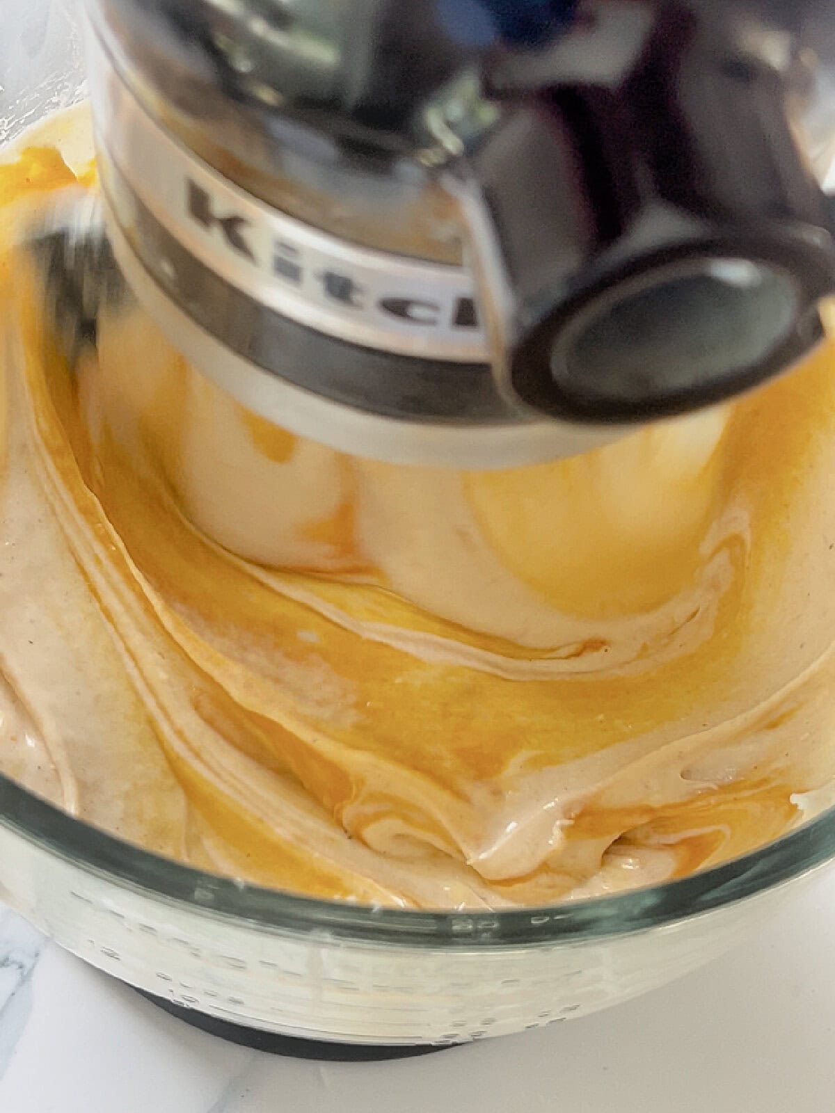 Pumpkin cheesecake batter being mixed together in the mixer.